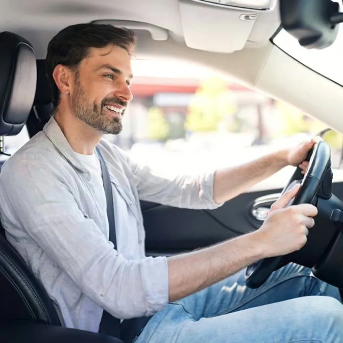 Driver behind the wheel on the road after fitting the SynGas OBD2 fuel-saving device